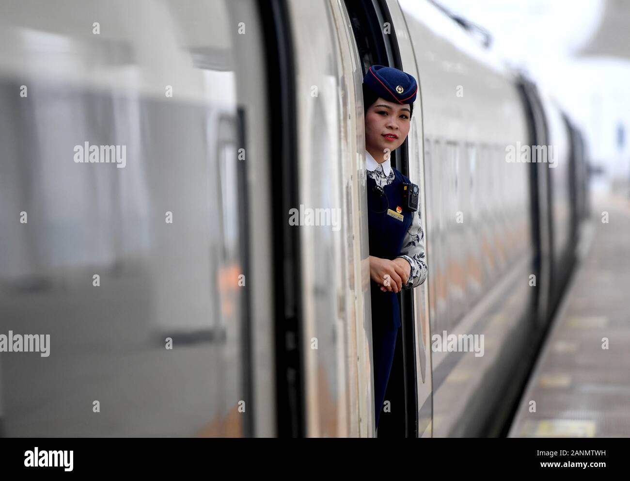 (200118) -- ZHENGZHOU, Jan. 18, 2020 (Xinhua) -- Jiang Yuanyue checks the platform for passengers boarding train G3105, Jan. 17, 2020. Jiang Yuanyuan, an attendant born in the new millenium, is getting ready for her first Spring Festival travel rush work as an attendant.   To be an attendant on a high-speed train has always been Jiang's dream. After making her debut in the job, she tried hard to keep up with the fast pace and learn to get along with various passengers. As she tried and persisted, Jiang has grown into a professional and proficient attendant.    As the job requires Jiang to work Stock Photo