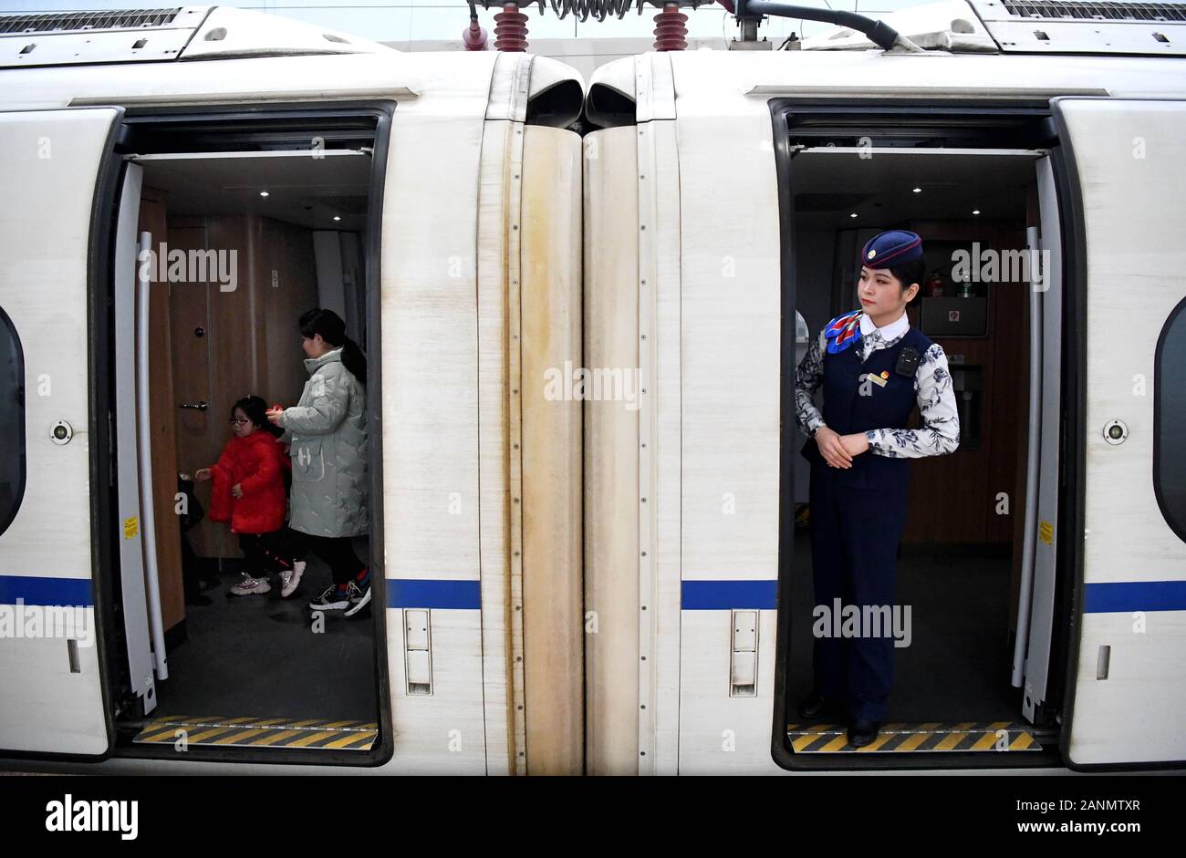 (200118) -- ZHENGZHOU, Jan. 18, 2020 (Xinhua) -- Jiang Yuanyue checks if all passengers finished boarding train G3105, Jan. 17, 2020. Jiang Yuanyuan, an attendant born in the new millenium, is getting ready for her first Spring Festival travel rush work as an attendant. To be an attendant on a high-speed train has always been Jiang's dream. After making her debut in the job, she tried hard to keep up with the fast pace and learn to get along with various passengers. As she tried and persisted, Jiang has grown into a professional and proficient attendant. As the job requires Jiang to work Stock Photo