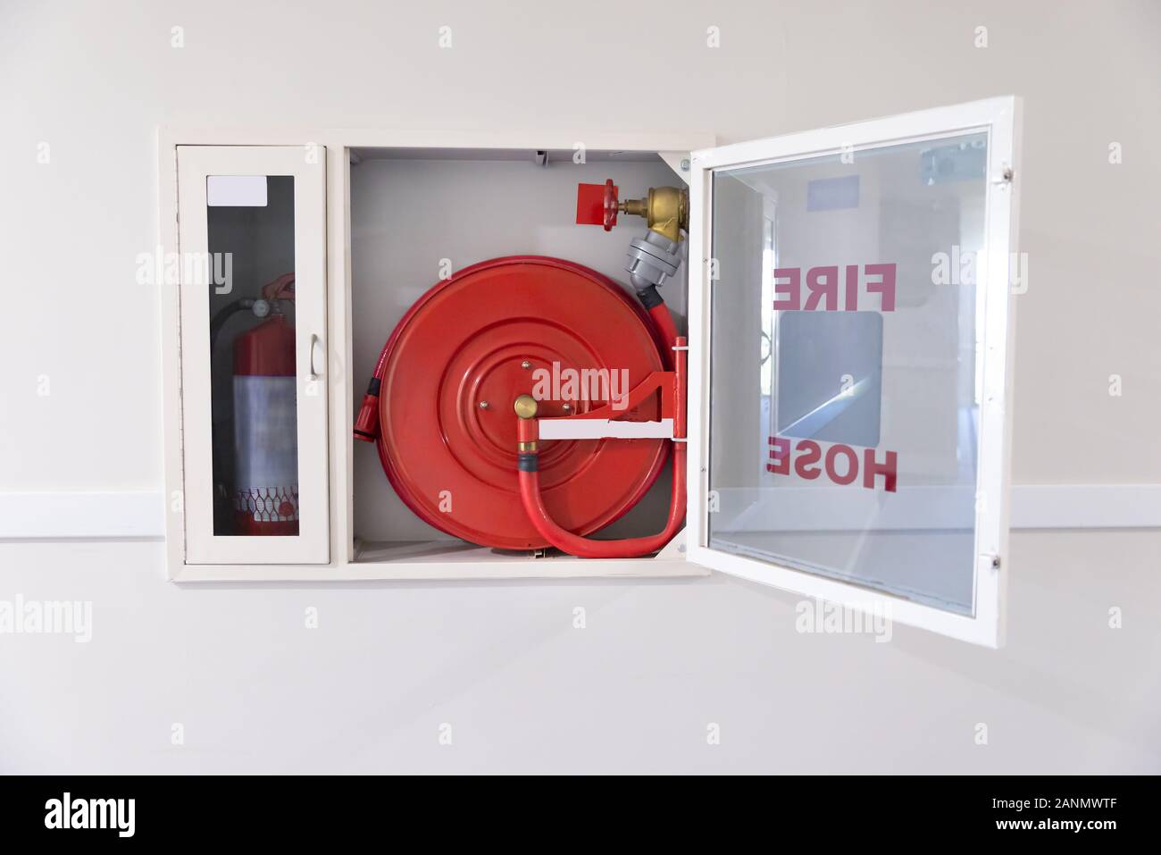 Fire Hose Reel And Fire Extinguisher In Hotel Corridor Stock Photo