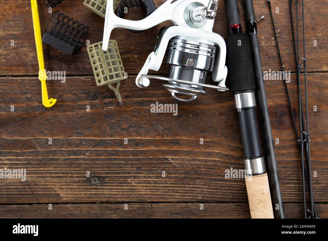 flat lay with fishing tackle, fishing rod and plastic box with fishing  tackle and hooks, feeders on wooden planks, copy space Stock Photo - Alamy