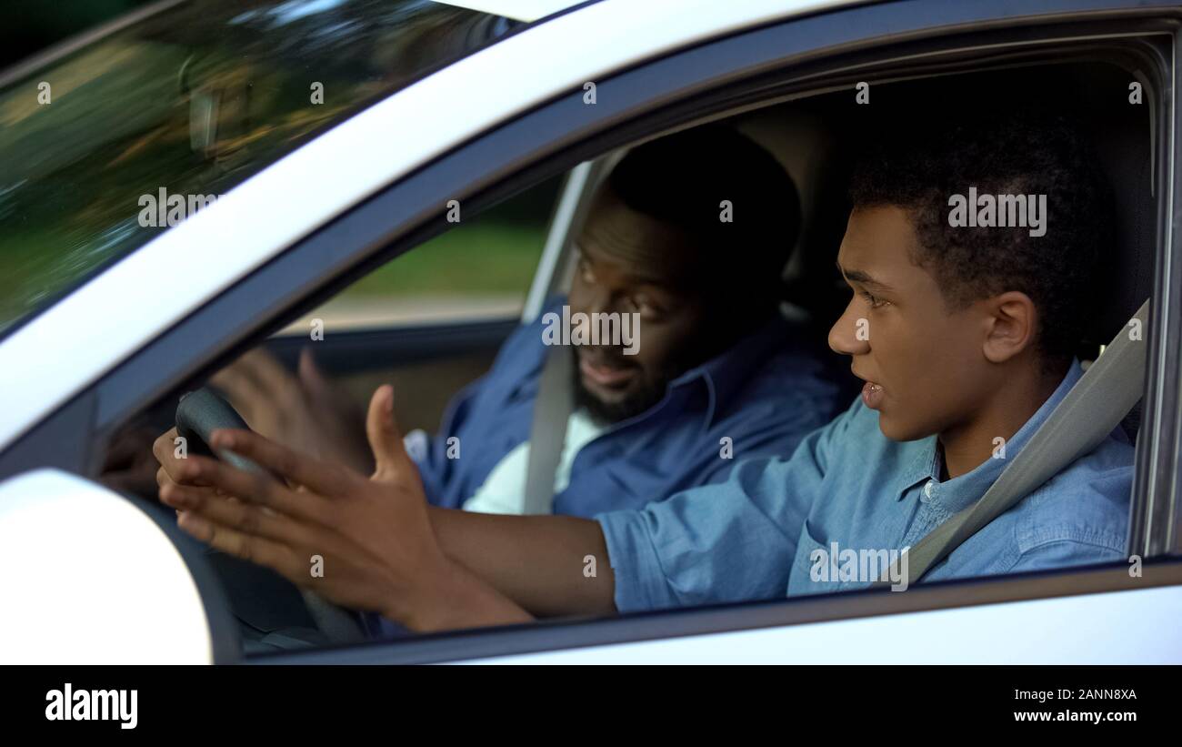 Son feeling scared of strict father teaching drive, parenthood misunderstanding Stock Photo