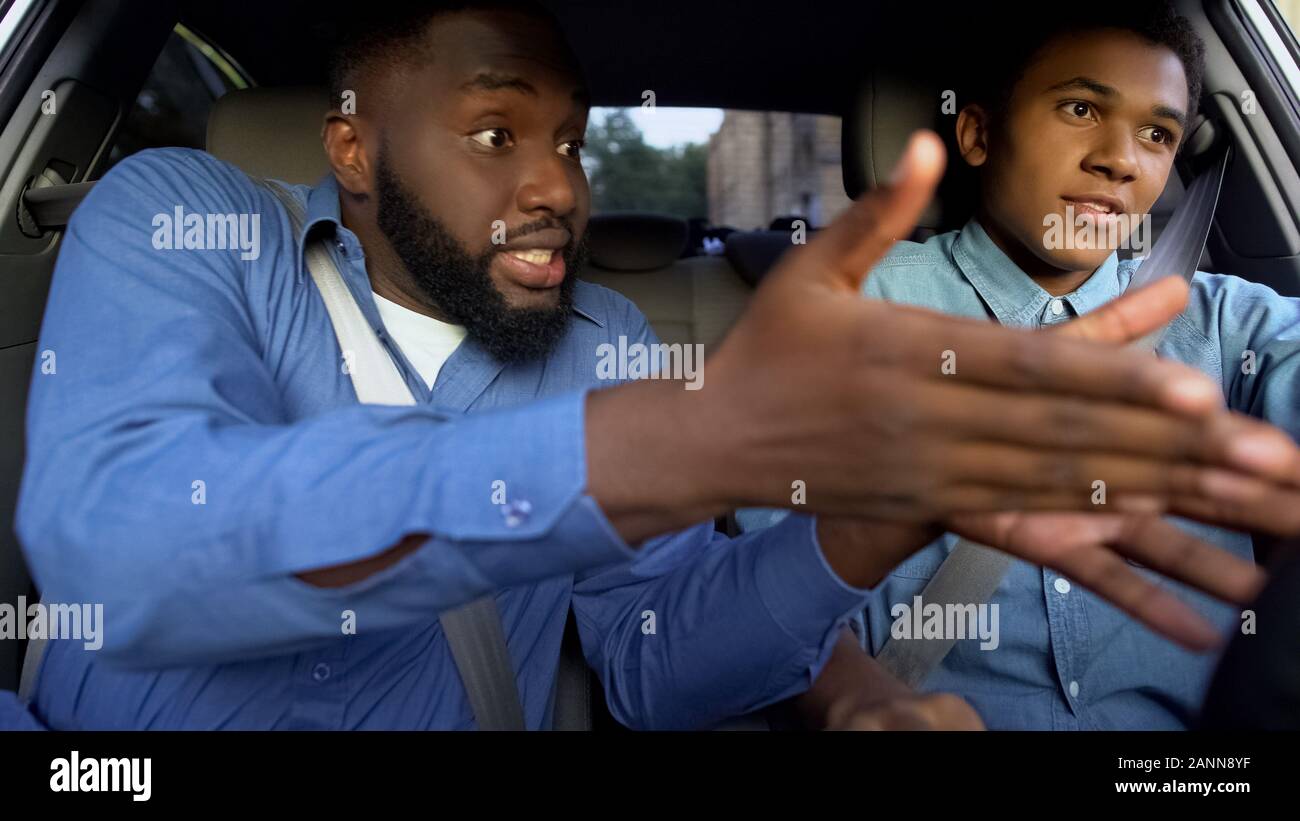 Black father and son arguing sitting car together, generations misunderstanding Stock Photo