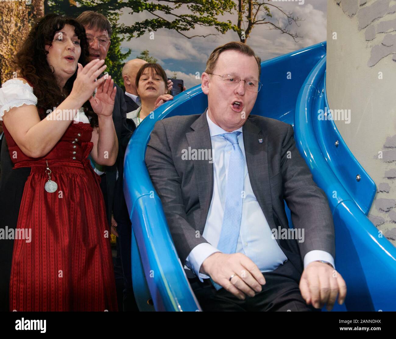 Berlin, Germany. 18th Jan, 2020. Bodo Ramelow (r, Die Linke), Minister President of Thuringia, slides on a children's slide at the Green Week. Petra Enders, district administrator of the Ilm district in Thuringia, claps her hands. Credit: Annette Riedl/dpa/Alamy Live News Stock Photo