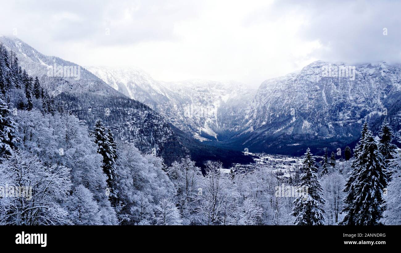 Scenery dreamscape of Hallstatt Winter snow mountain landscape valley and lake through the forest in upland valley leads to the old salt mine of Halls Stock Photo