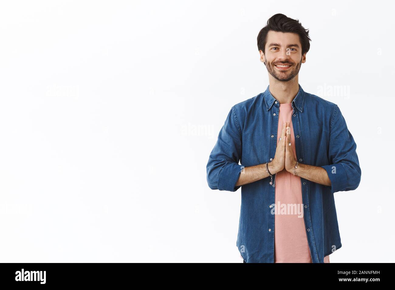 Relieved, happy good-looking relaxed guy practice yoga or meditating, standing straight with hands clasped near chest in namaste gesture, smiling grat Stock Photo