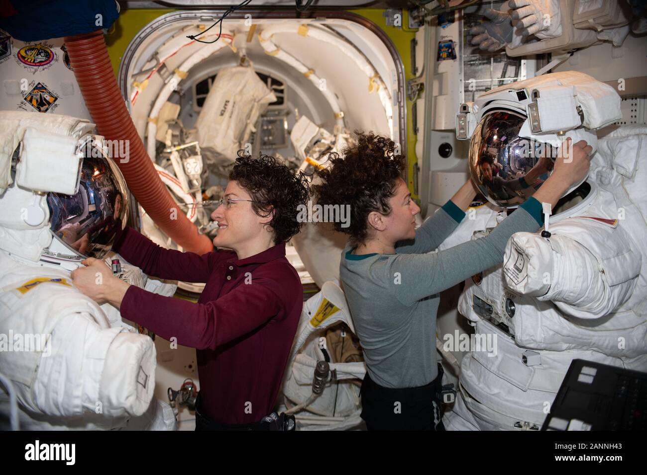 ISS - 15 Jan 2020 - NASA astronauts Christina Koch (left) and Jessica Meir work on their U.S. spacesuits ahead of a spacewalk they conducted to instal Stock Photo