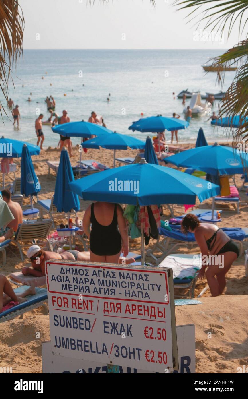 Agia Napa, Cyprus - Oct 26, 2019: Beach stand with cost of beach sunbeds and umbrella Stock Photo