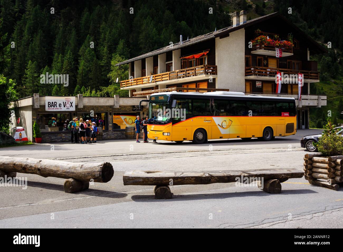 Zinal, Valais, Switzerland - August 7 2018 : a yellow PostAuto bus and picking up tourists in the alpine village Zinal at the end of the Val d' Annivi Stock Photo