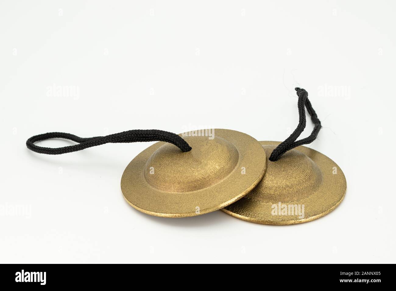 Closeup of a pair of finger cymbals lying on a white underground Stock Photo