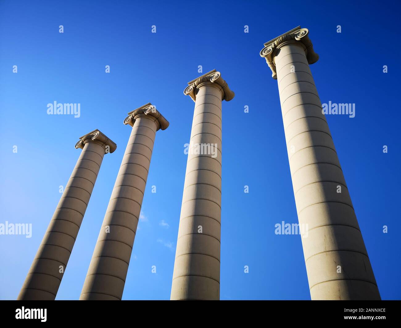 Ancient marble columns on blue sky view from ground roman temple building Stock Photo