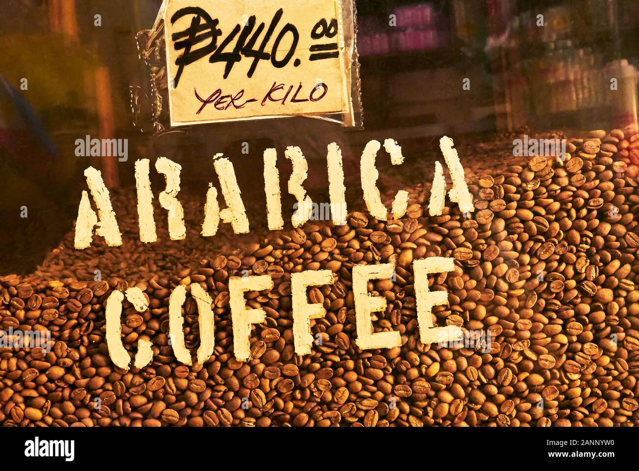 Roasted Arabica coffee beans for sale are displayed with price sign behind glass at a traditional store at Divisoria market in Manila, Philippines Stock Photo
