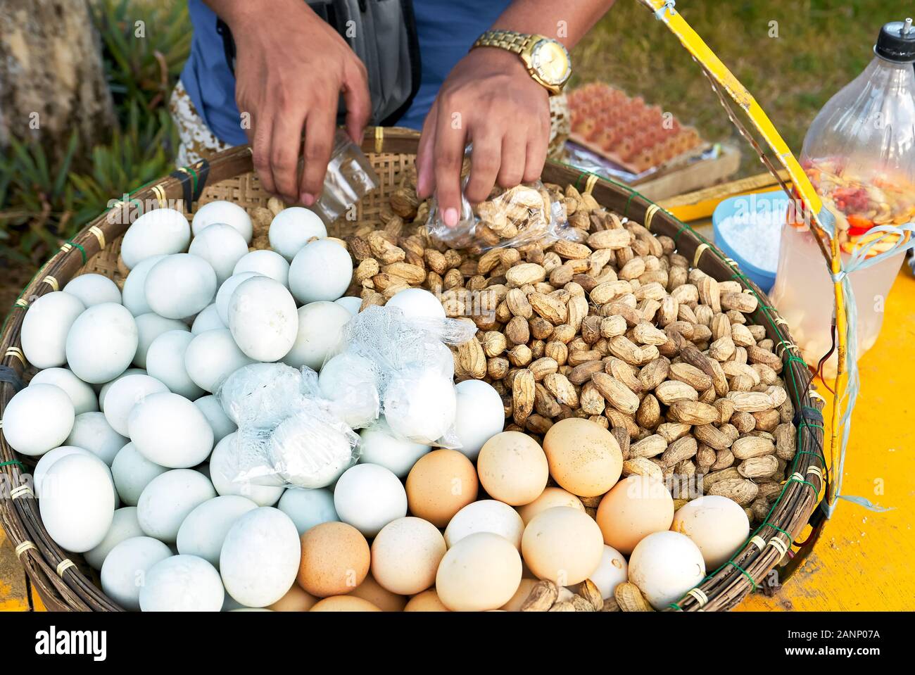 Close-up of steamed peanuts and white and brown boiled eggs, nicely presented in a native bamboo tray, sold by a street vendor in the Philippines Stock Photo