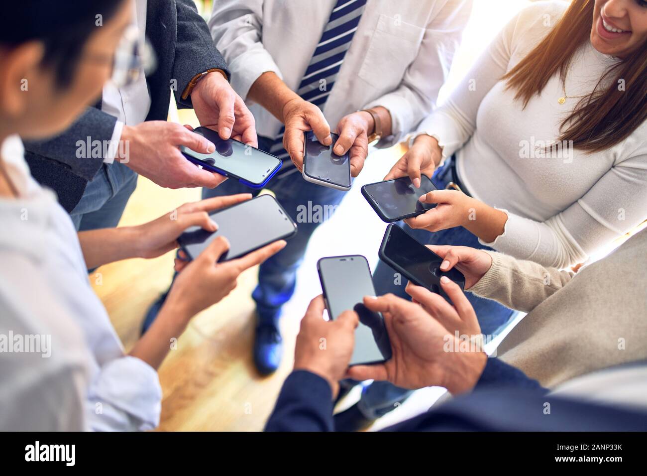 Worker Using Smartphone Group of business workers standing with hands together using smartphone ...