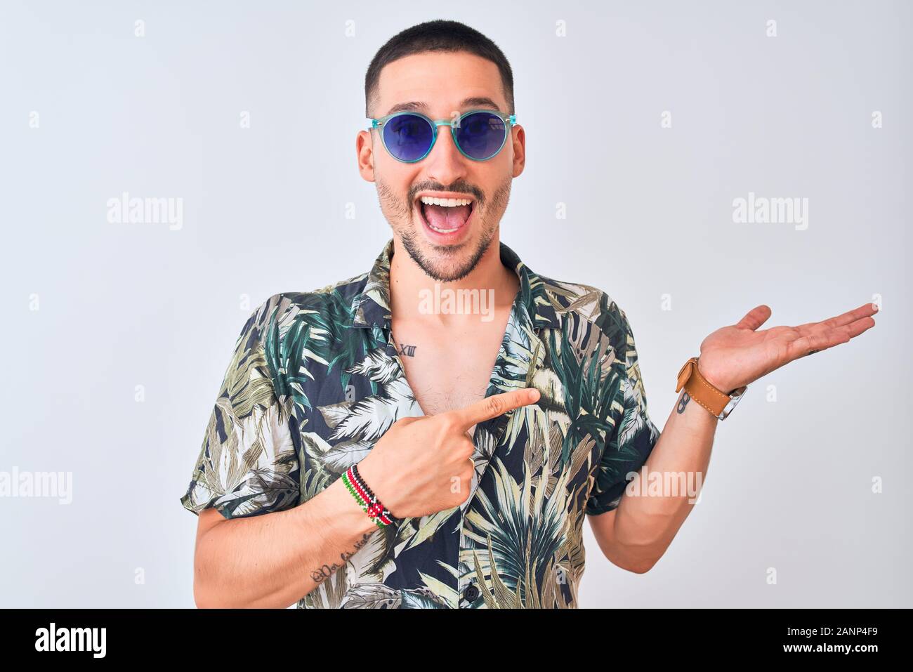Young handsome man wearing Hawaiian sumer shirt and blue sunglasses ...