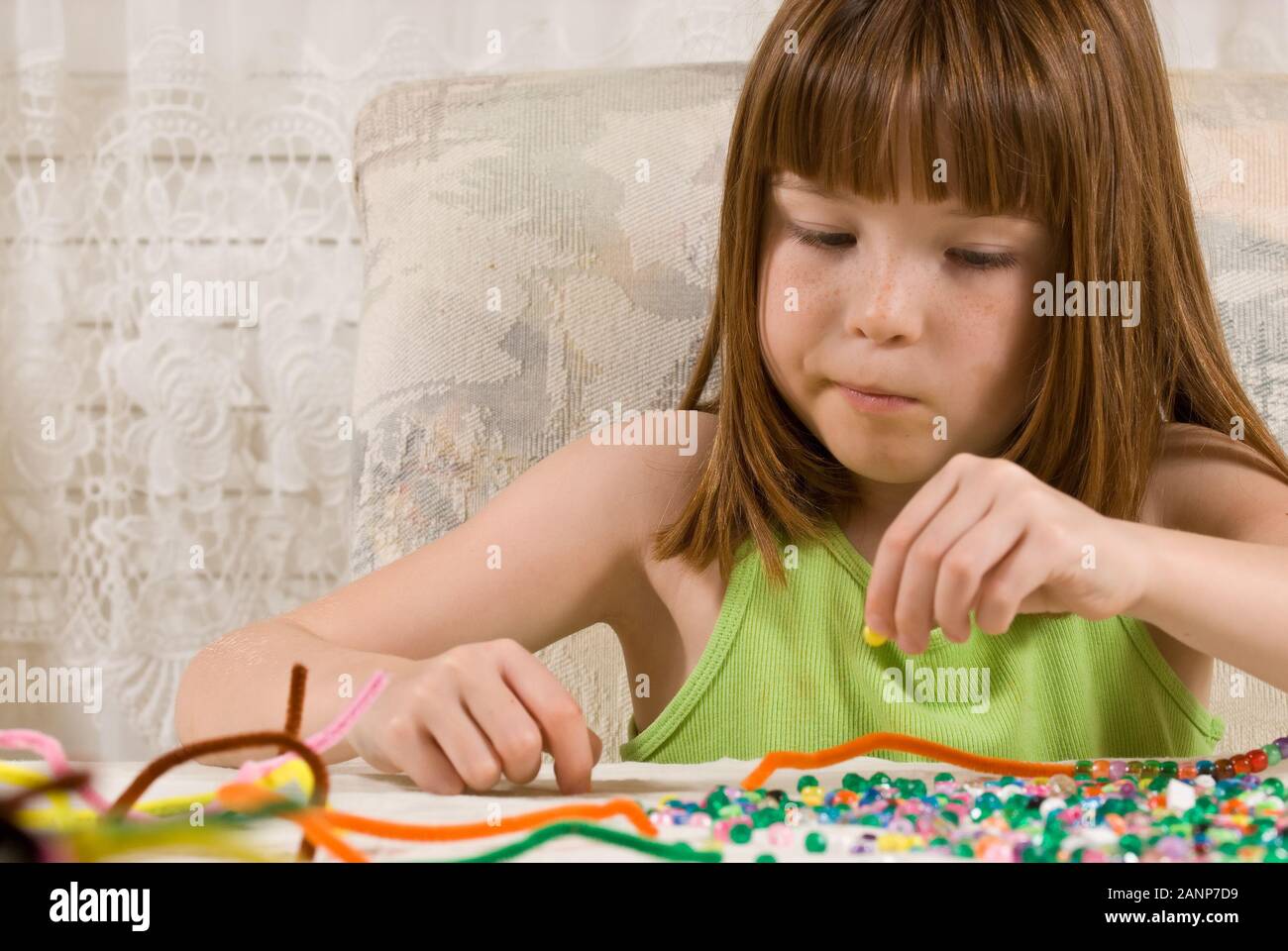 Young girl making bead bracelets Stock Photo Alamy