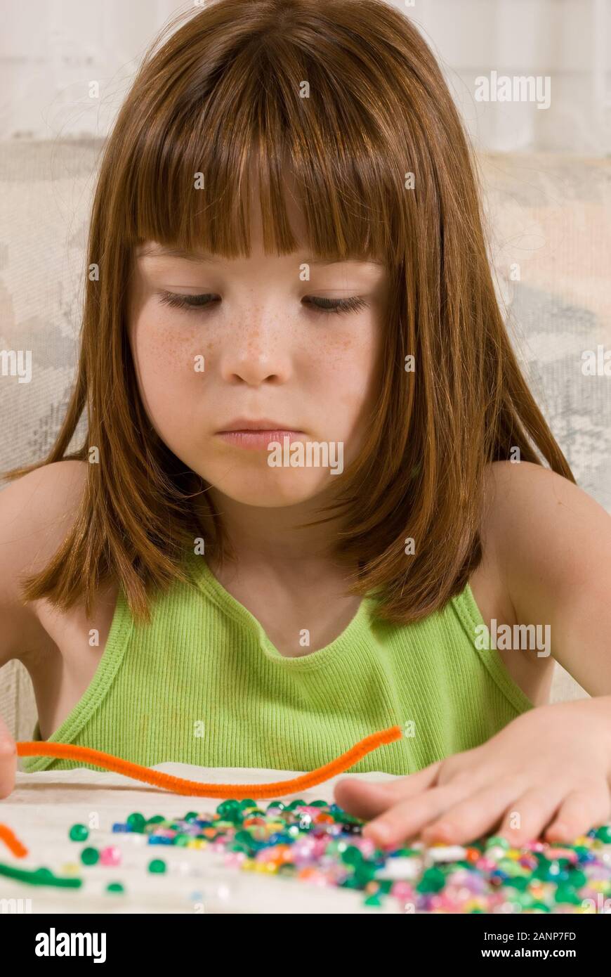 Young girl making bead bracelets Stock Photo Alamy