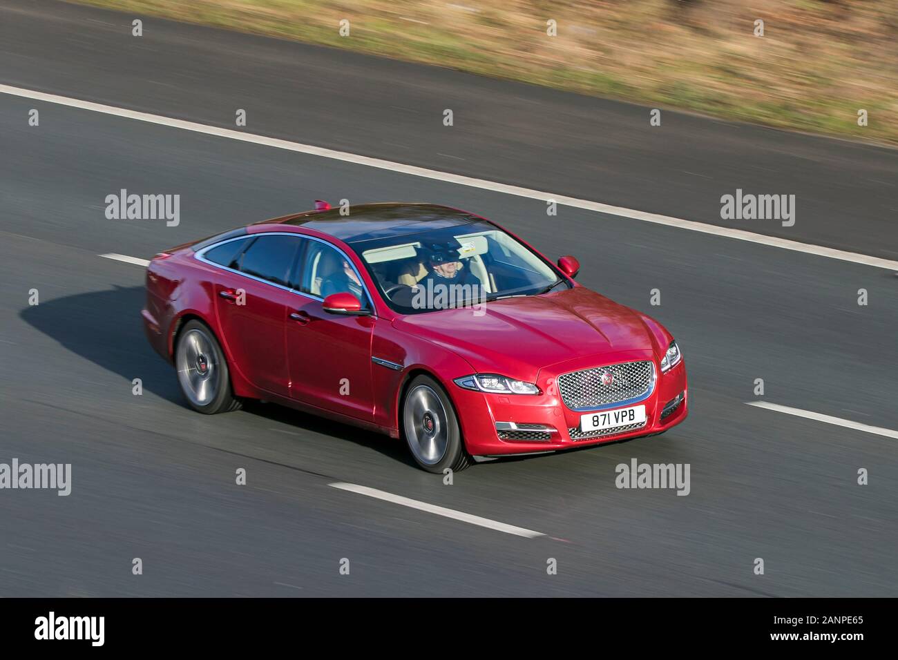 871VPB Jaguar Xj Premium Luxury V6 D Auto Diesel red car driving on the M6 motorway near Preston in Lancashire, UK Stock Photo