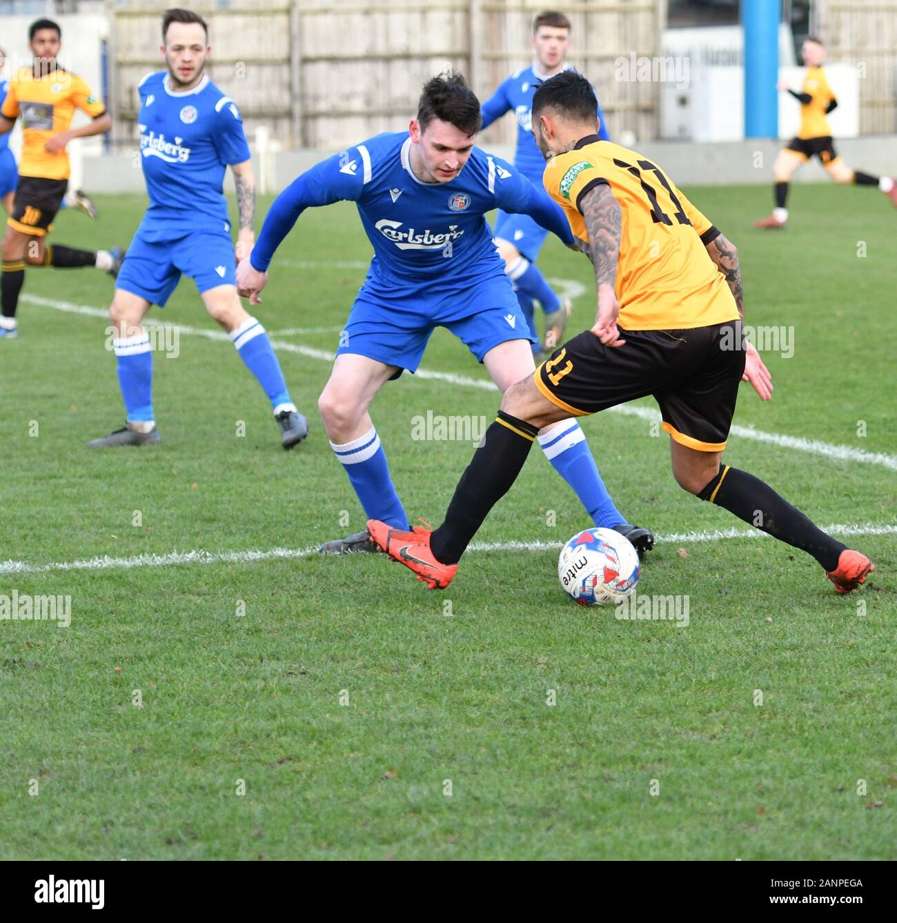 New Mills, Derbyshire  January 18th 2020 Action from the North West Counties League match between New Mills (amber and black)  and Wythenshawe Town (blue).Wythenshawe win 4-2. Stock Photo
