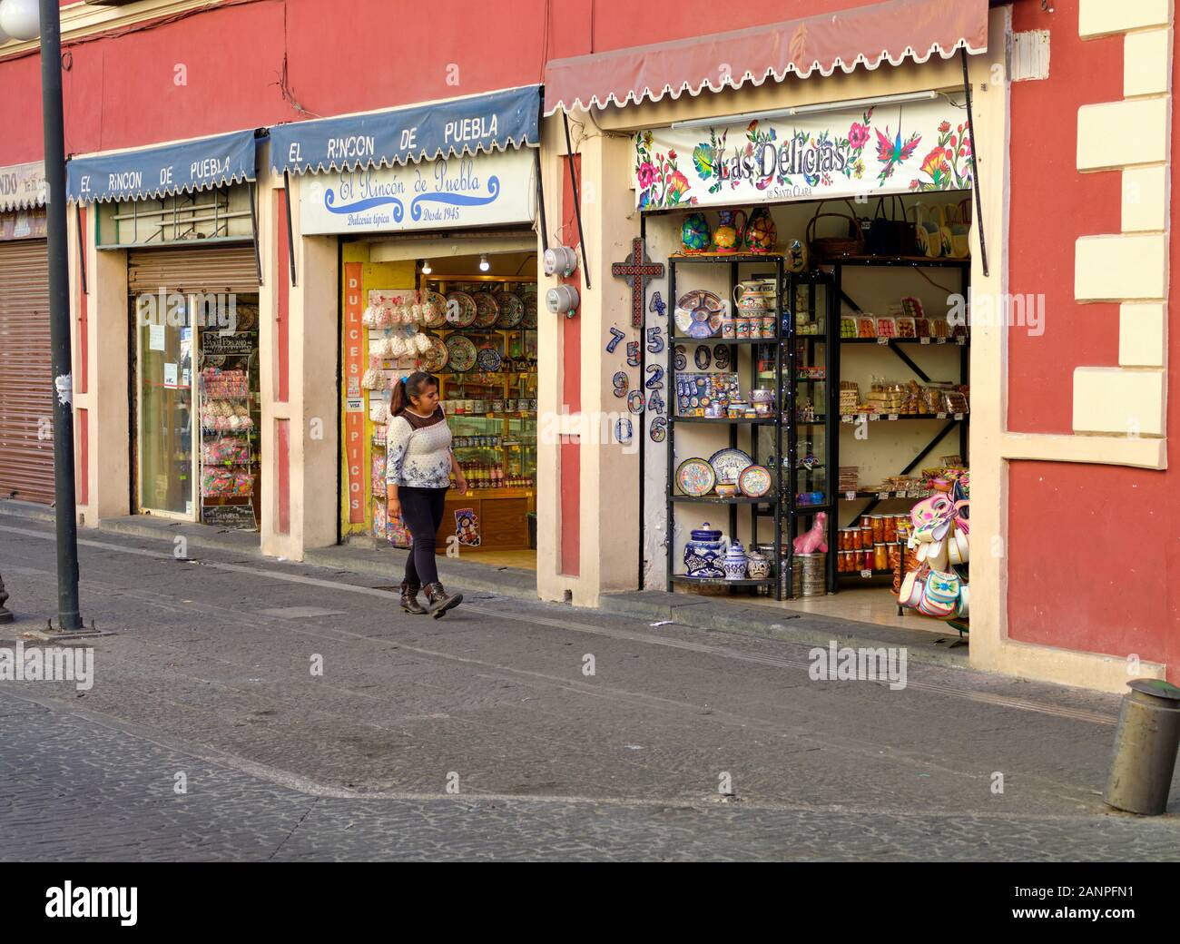 Person walking by shops on the Calle de los Dulces in Puebla (Street of the Sweets) Stock Photo