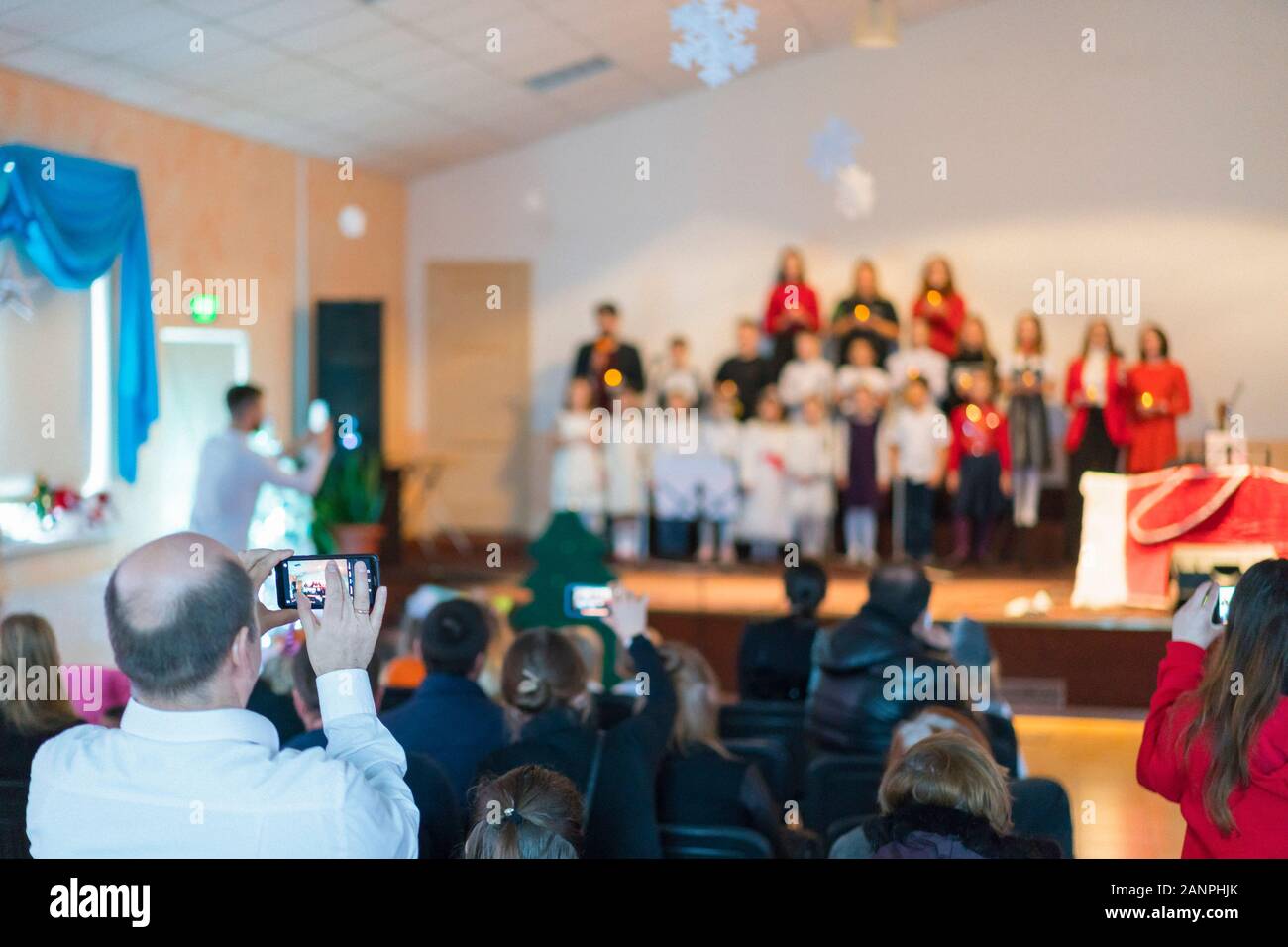 Many parents are watching the kids performance in the hall. Children on ...