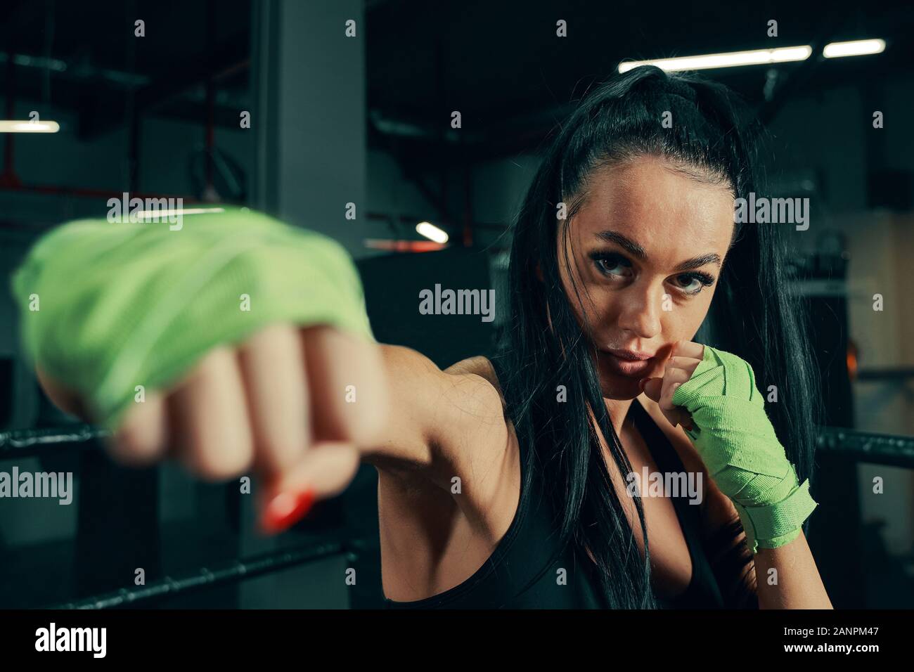 Athletic woman standing prepared for fight with boxing bandages on
