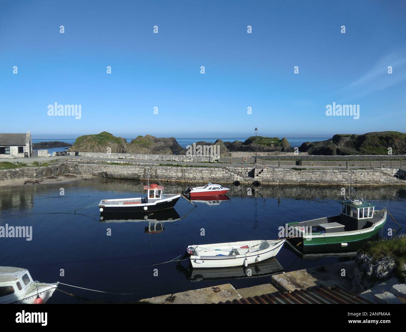 Small harbor in northern Ireland with little boats on a sunny day Stock Photo