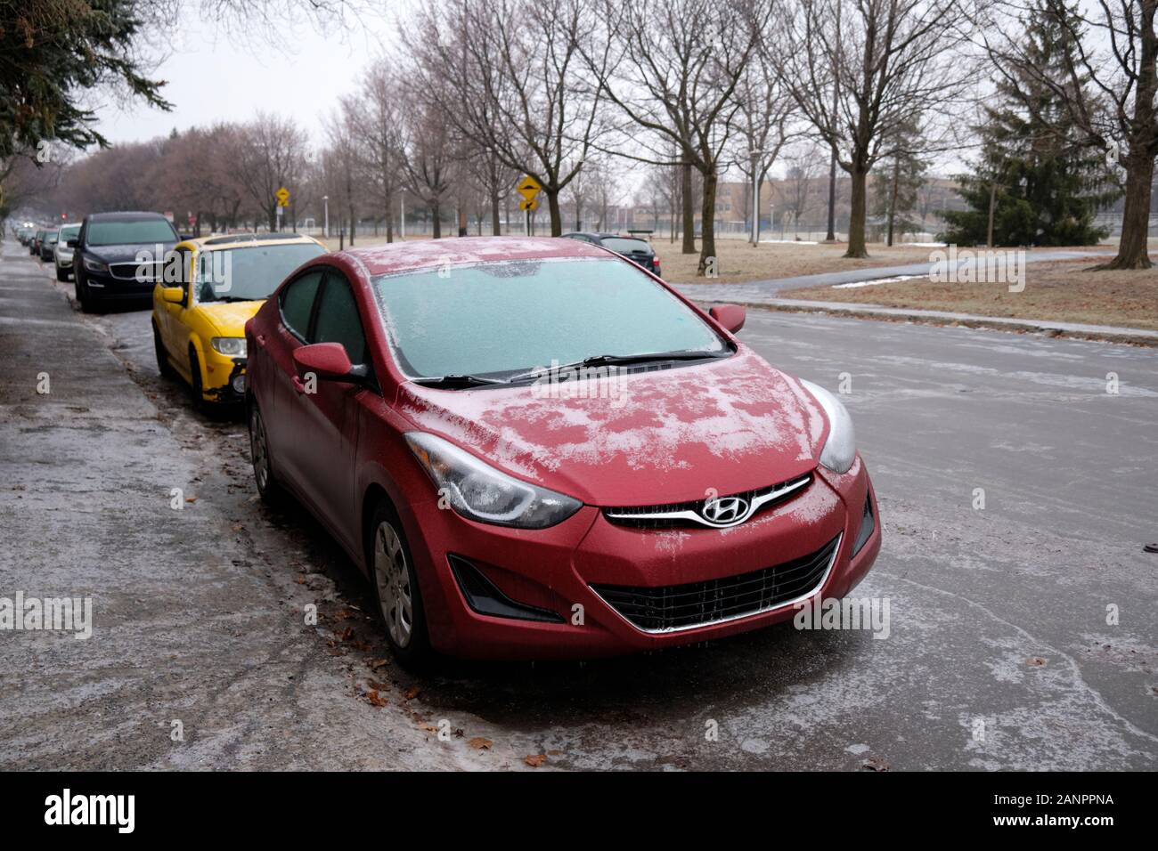 Montreal street with cars covered in ice falling freezing rain storm in residential neighbourhood Stock Photo