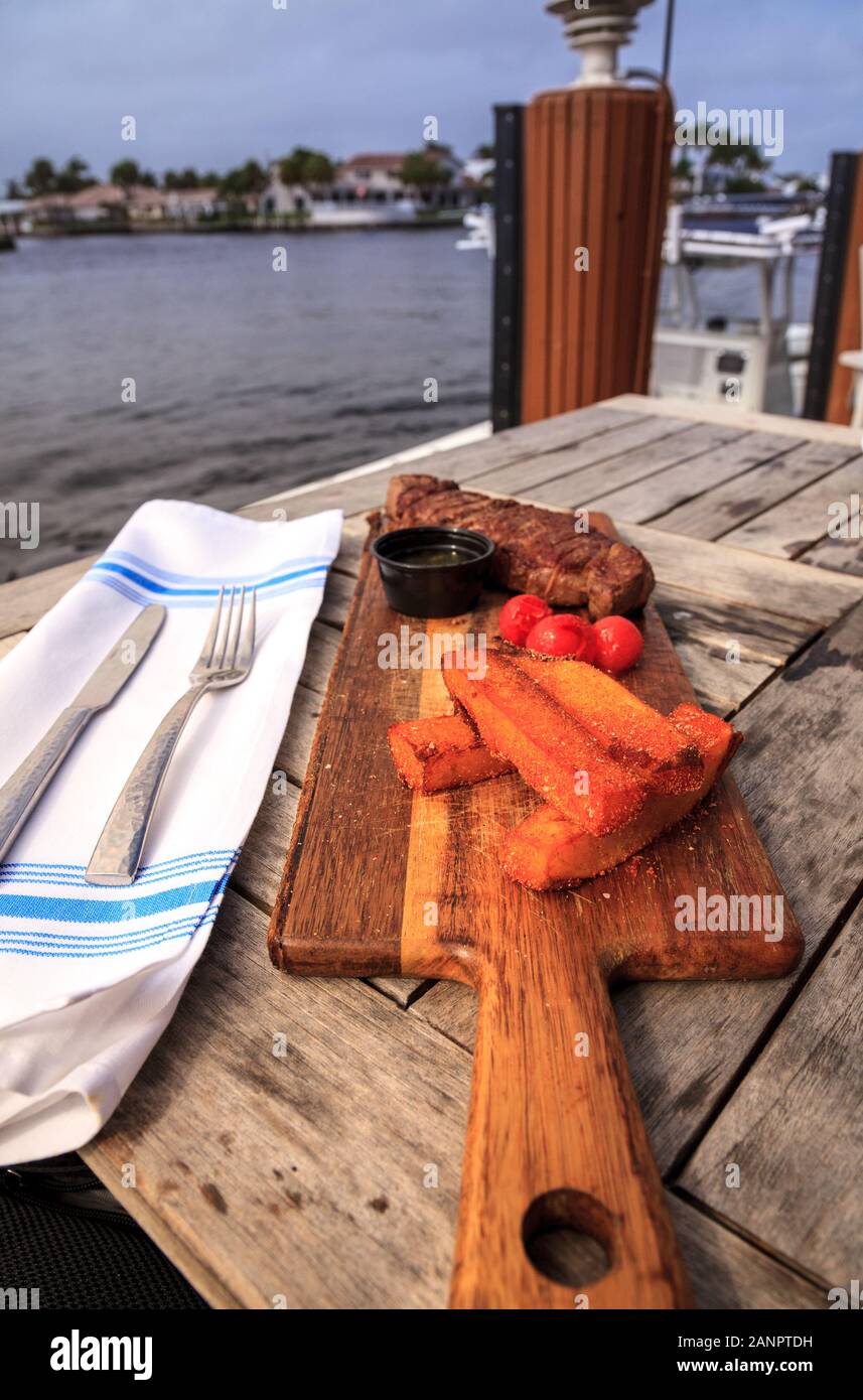 Steak, gourmet thick French fries and chimichanga sauce dinner at an