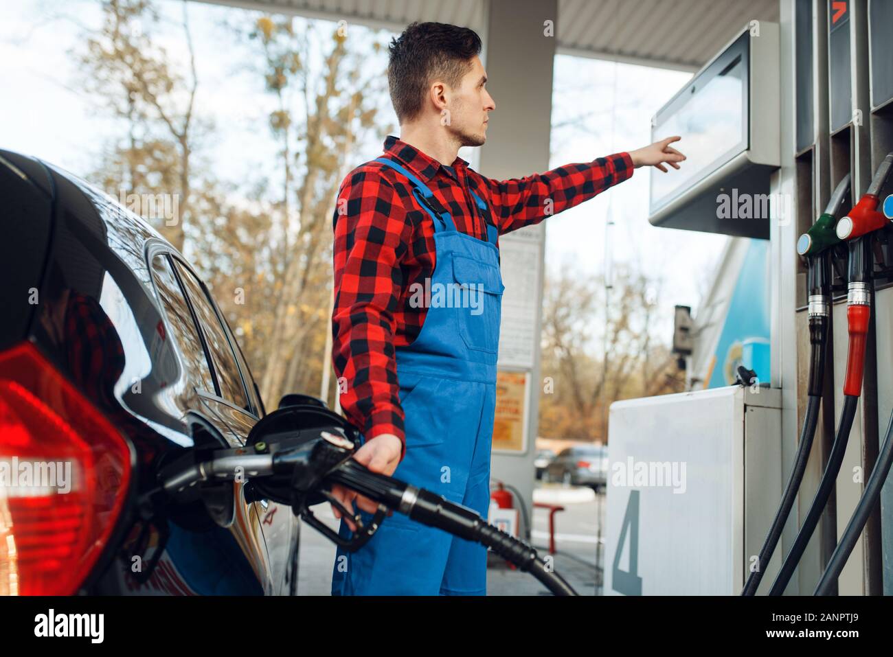Male worker in uniform fuels car on gas station Stock Photo - Alamy