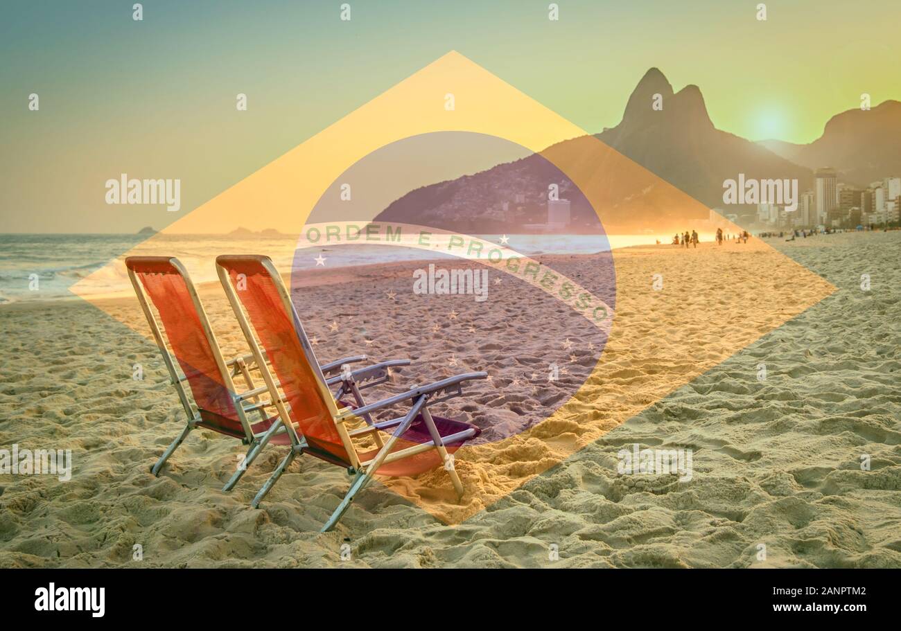 Beach deck chair against a backdrop of Two Brothers Mountain in Rio de Janeiro, Brazil at sunset. Brazilian flag superimposed on foreground Stock Photo