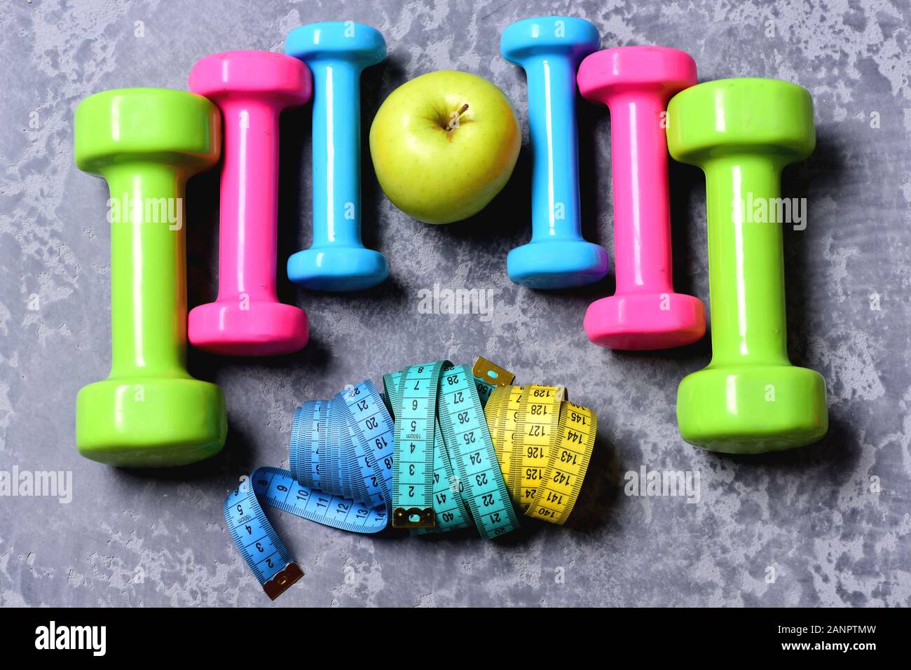 Barbells Colorful Tape Measures And Apple Placed In Pattern Top View Dumbbells Made Of Pink Green