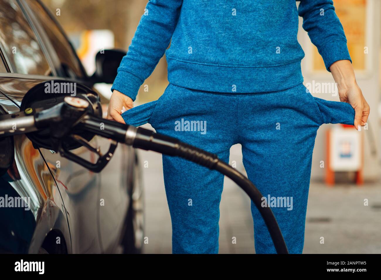 Female person with empty pockets on gas station Stock Photo Alamy