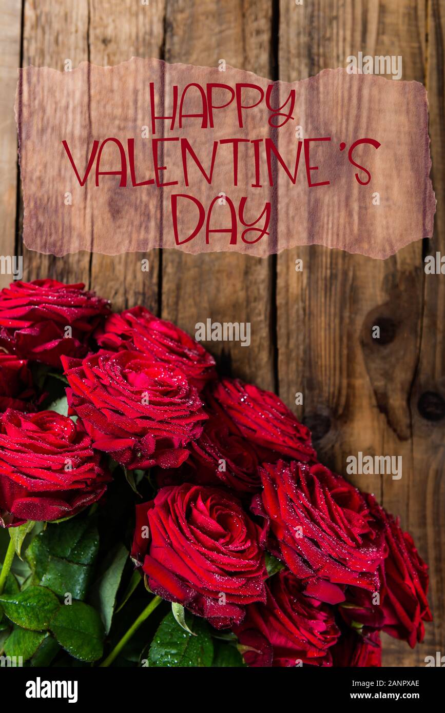 Bunch of Red Roses with Happy Valentines Day slogan on wooden