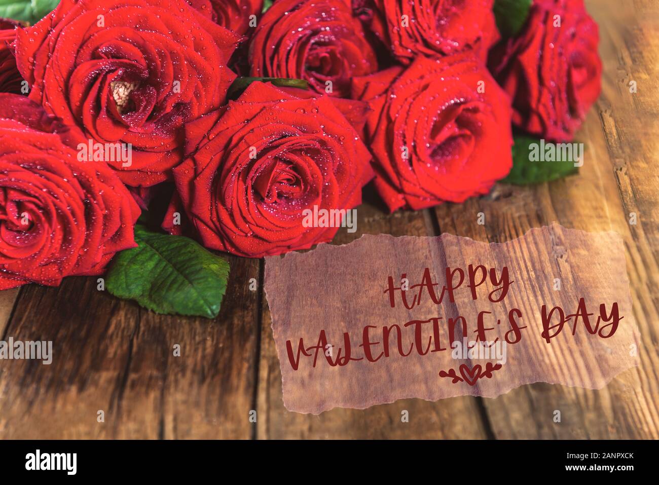 Bunch of Red Roses with Happy Valentines Day slogan on wooden