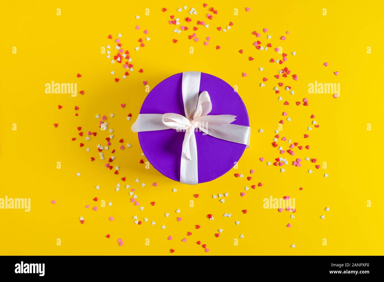 a violet gift box on yellow background. Stock Photo