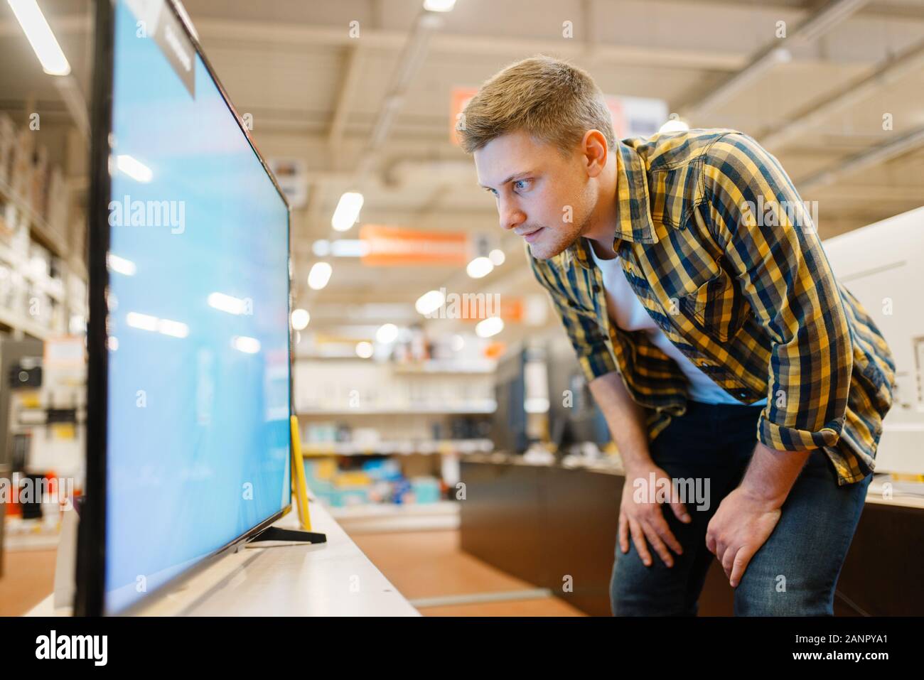 Man choosing TV in electronics store Stock Photo