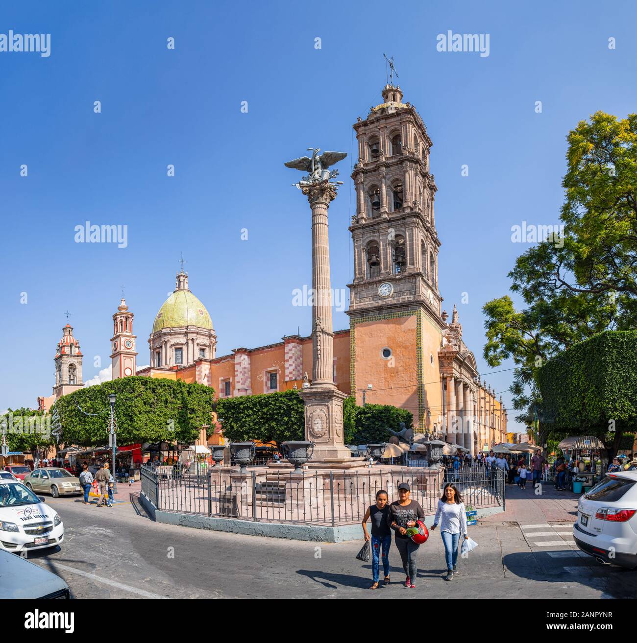 Celaya, Guanajuato, Mexico - November 24, 2019: Tourists and locals around the Immaculate Conception Cathedral, with the Independence column at the fr Stock Photo