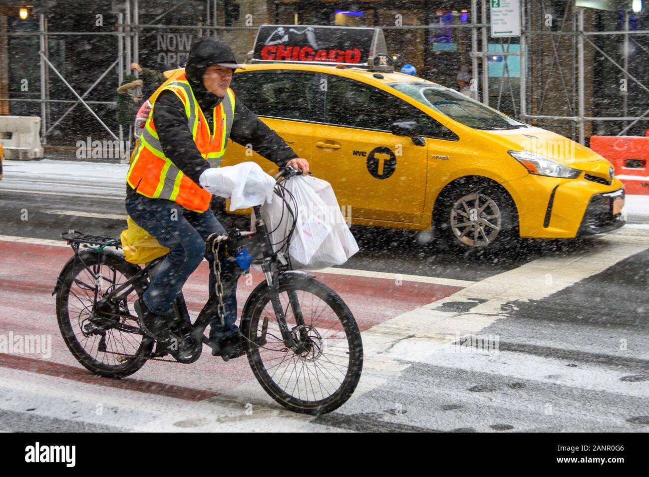 New York, USA,  18 January 2020. A delivery man from a Chinese restaurant works on his bycicle in New York City's Upper East Side during a snowstorm.   Credit: Enrique Shore/Alamy Live News Stock Photo