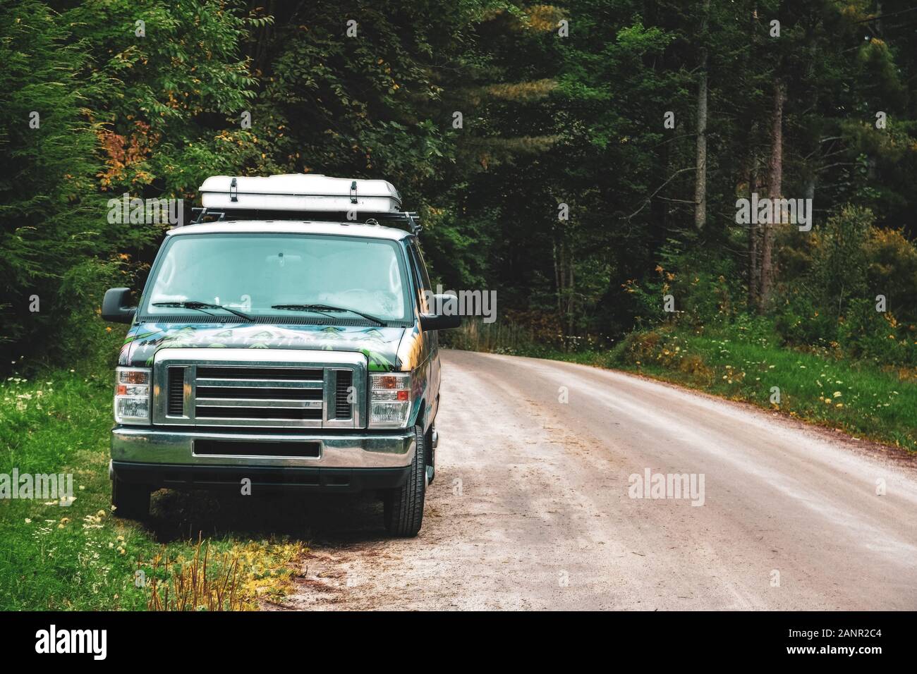 Van lifestyle concept. Van park in a path surrounded by trees in the forest in Canada. Stock Photo
