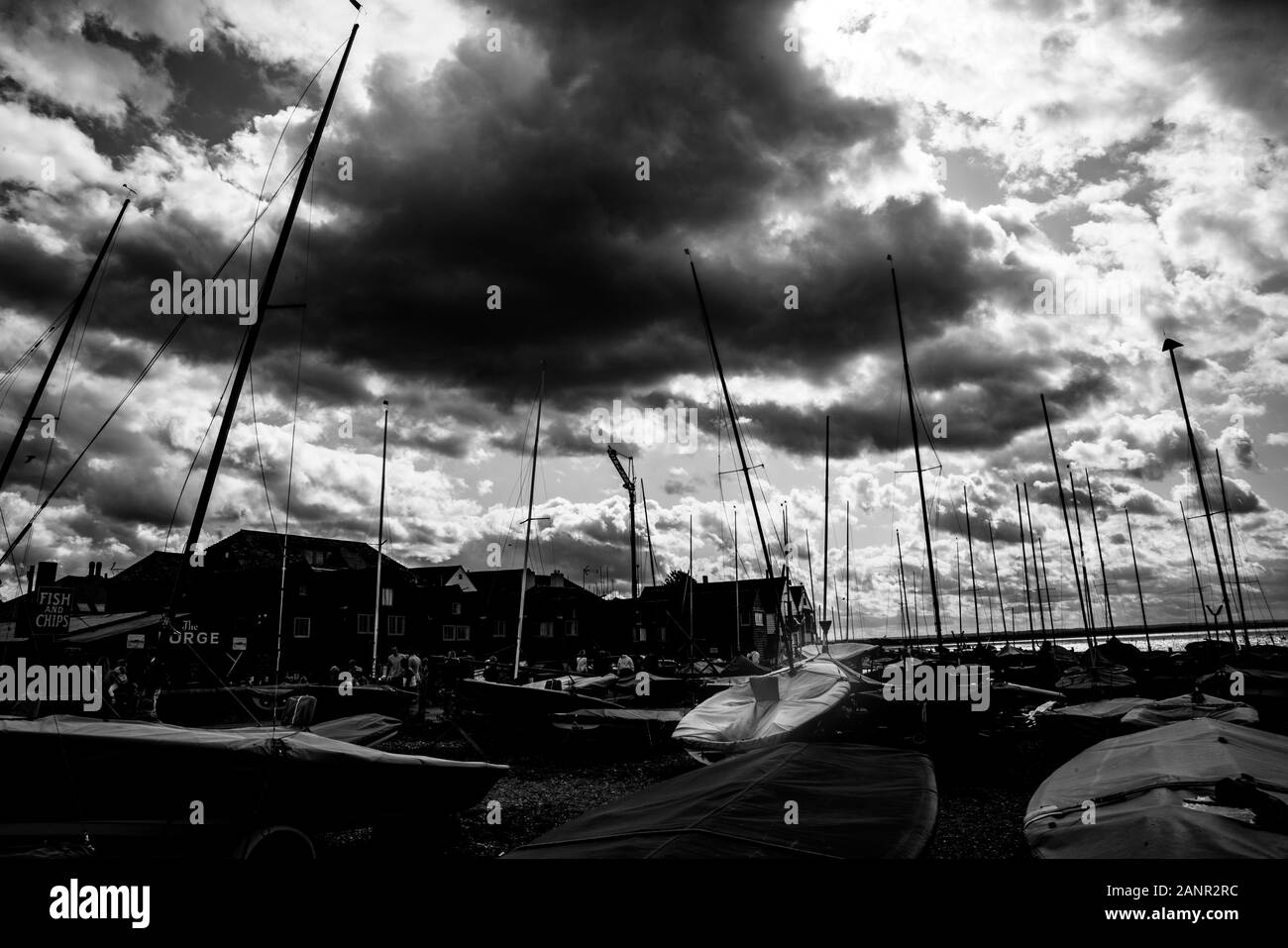 Yacht masts standout like prickles on procupine as darck clouds gather ofer Whitstable waterfront, England. Stock Photo