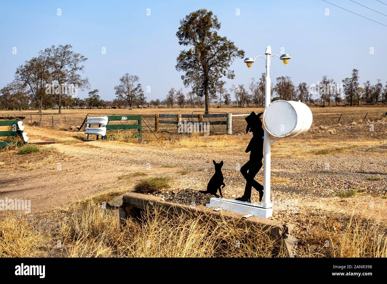 Man and His Dog Waiting for Mail on a side road in NSW, Australia. Example of a great Australian letterbox with a sense of humor. Stock Photo