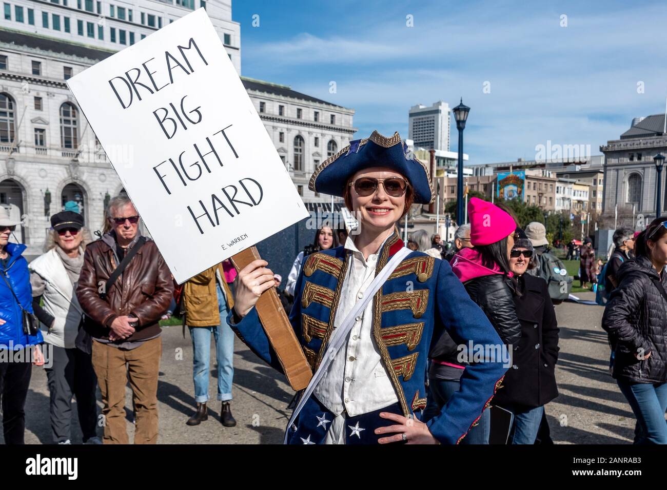 San Francisco, USA. 18th January, 2020. The 4th annual Women's March San Francisco, California. A woman dressed in 1776 costume holds a sign reading, "Dream big, fight hard," an Elizabeth Warren campaign slogan. Stock Photo