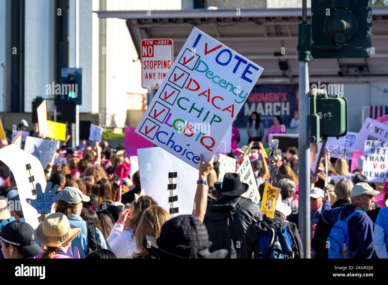 A crowd of activists at the 2020 Orange County Women’s March hold signs with pro-choice, LGBTQ, Blue Wave and other progressive messages on them. Stock Photo