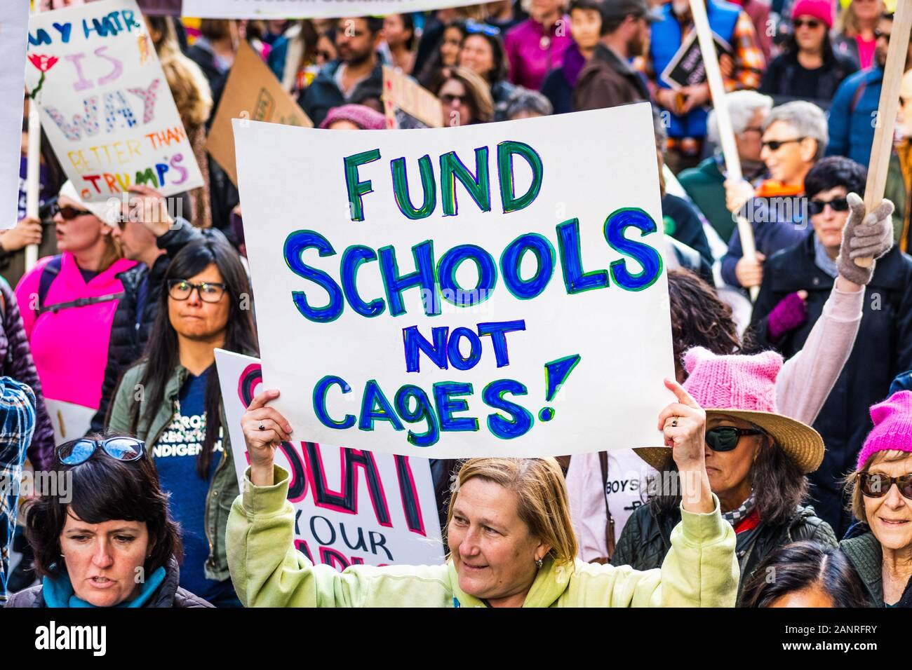 Jan 18, 2020 San Francisco / CA / USA - Participant to the Women's March event holds 'Fund Schools Not Cages' sign while marching on Market street in Stock Photo