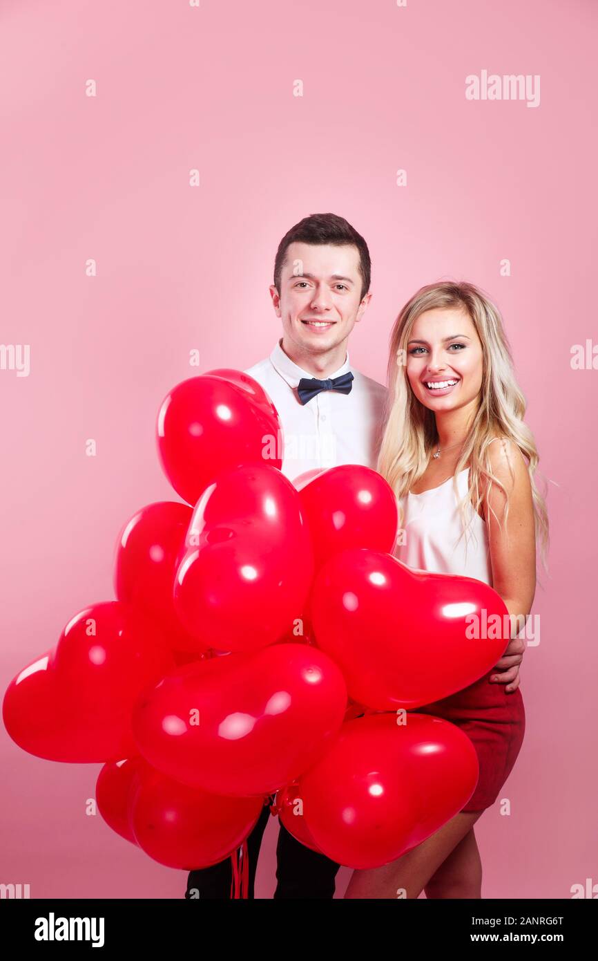 young loving couple with balloons heart on pink background Stock Photo ...