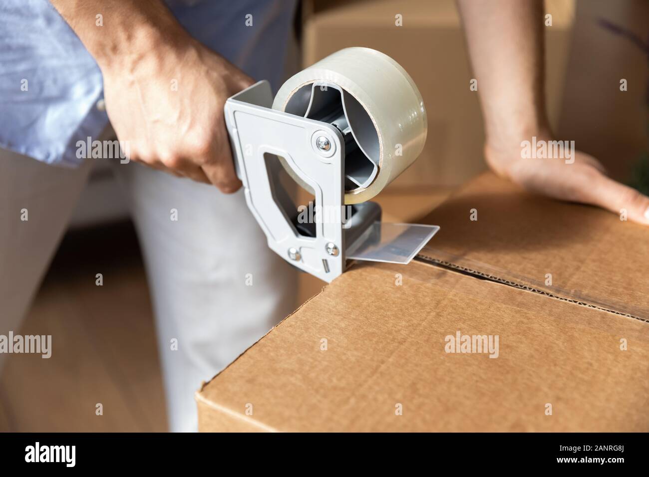 Male renter seal boxes with adhesive scotch moving Stock Photo Alamy