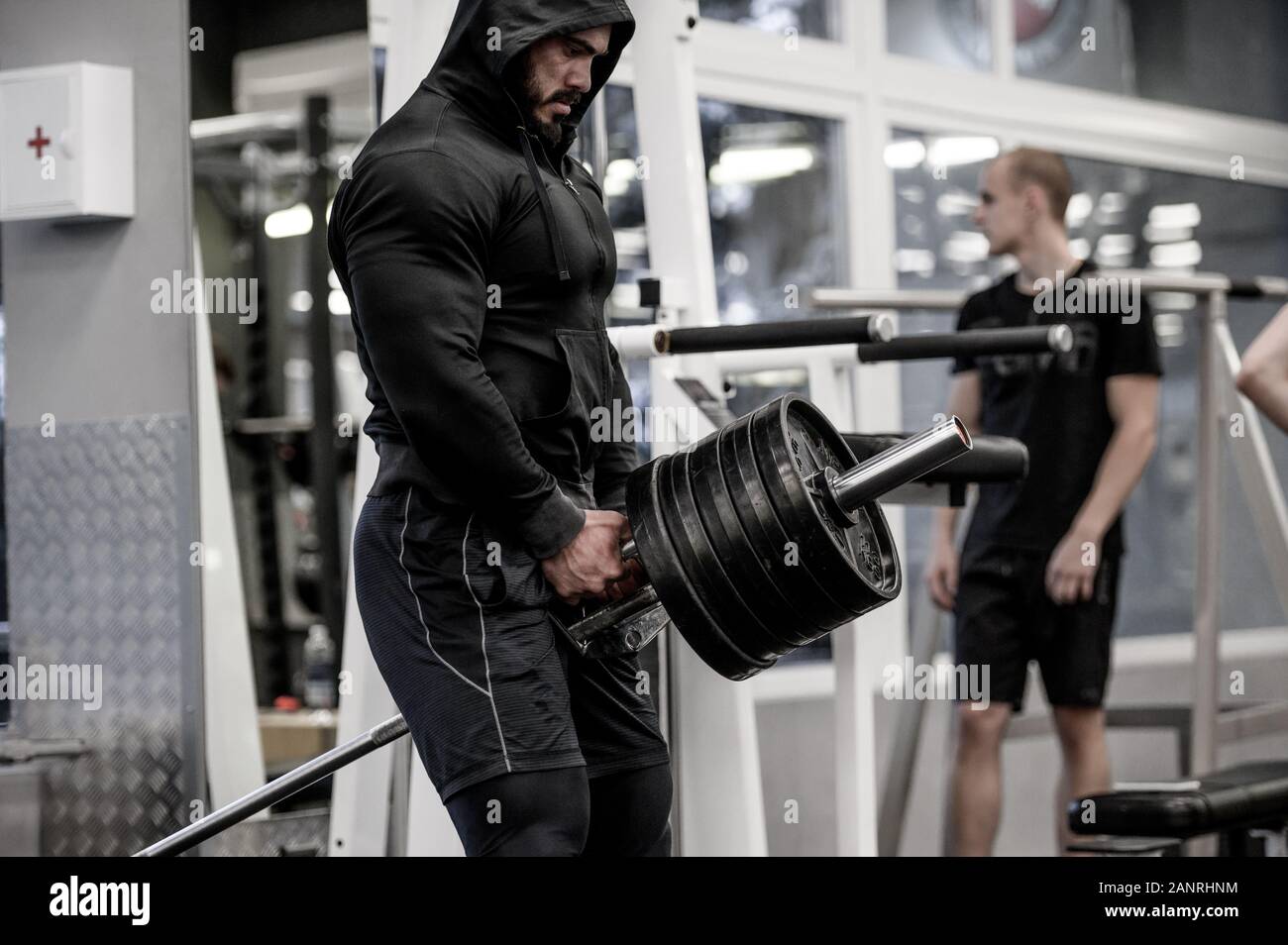 strong bearded man in hoodie lifting heavy barbell deadlift among people  indoors gym sport training workout Stock Photo - Alamy