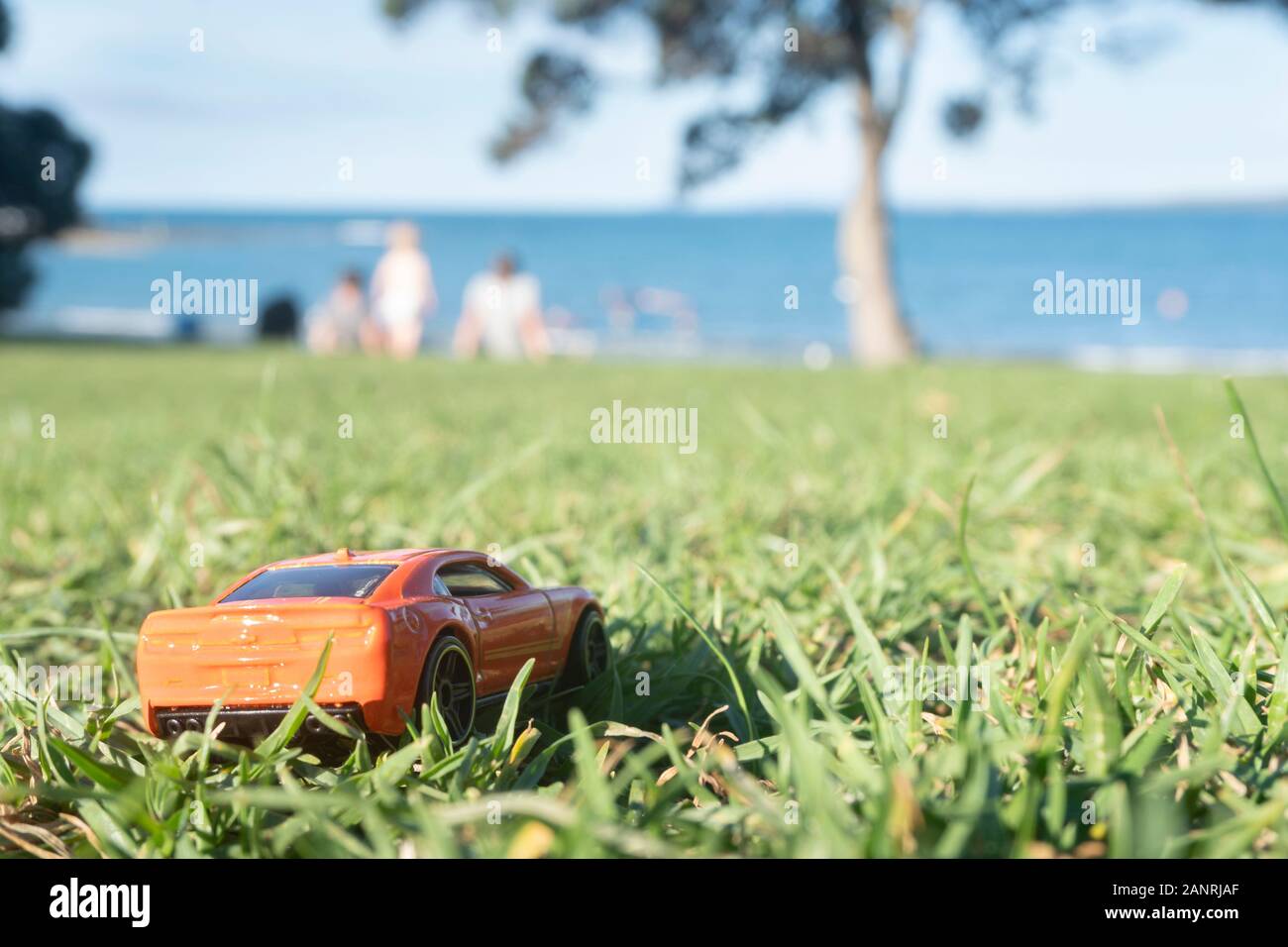 A toy car and family picnic at the beach - forced miniature perspective image Stock Photo