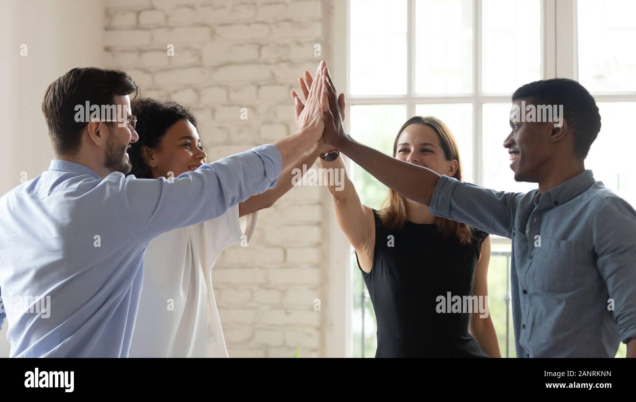 Happy diverse employees team giving high five, celebrating success ...