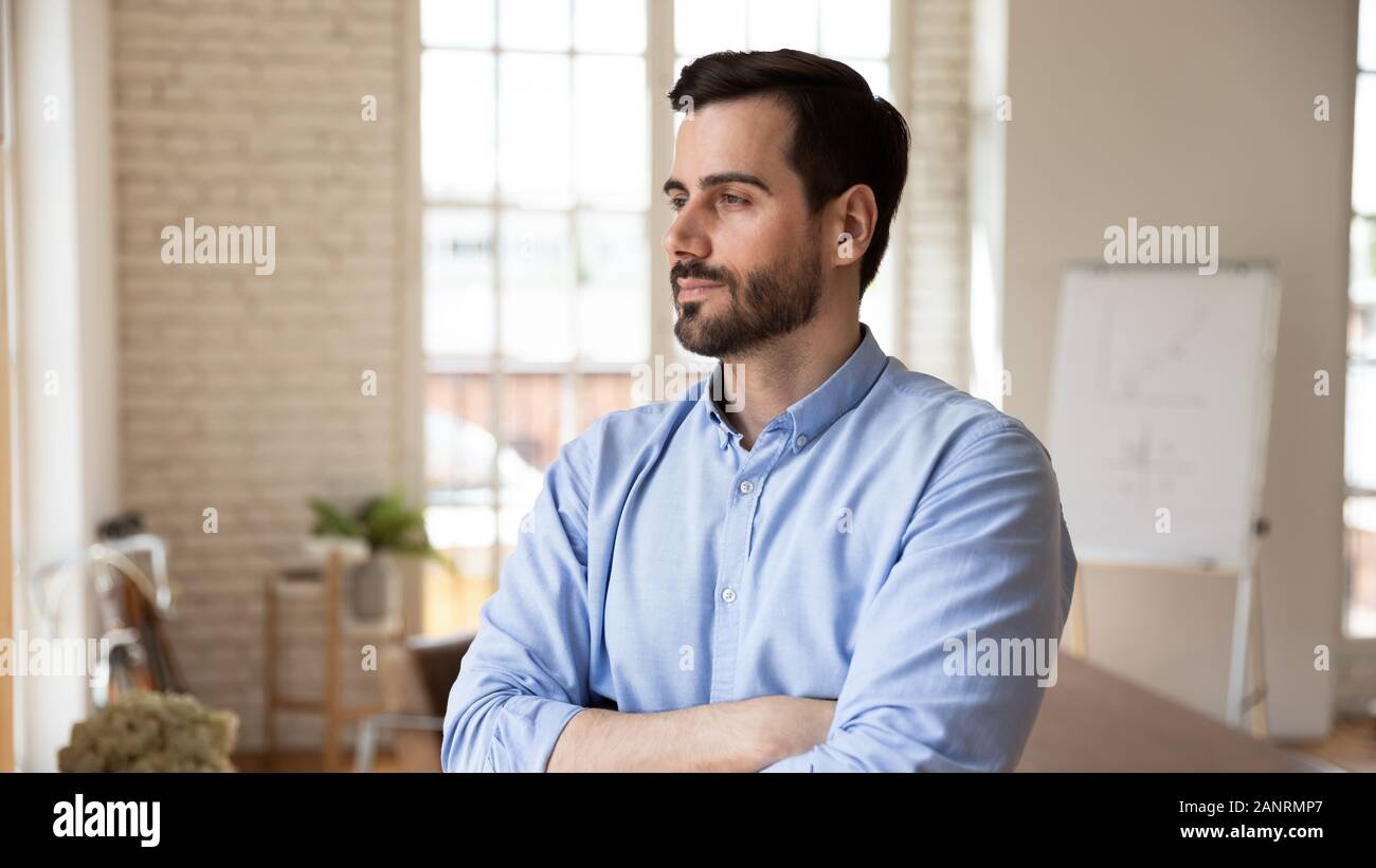 Thoughtful confident businessman looking in distance, pondering strategy Stock Photo